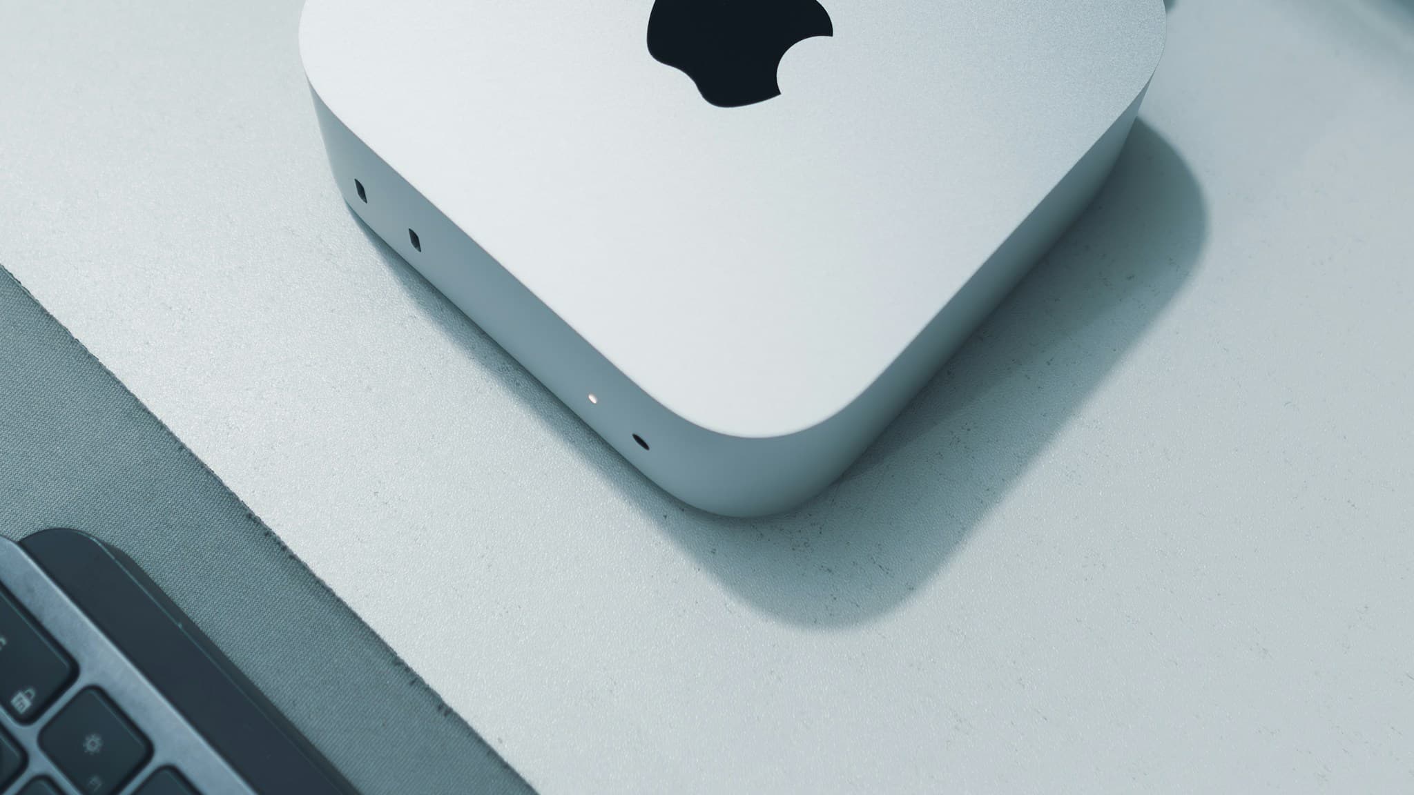 A real Apple Mac mini on a desk beside a keyboard, what does an ai agent do, Aceleron Intelligence
