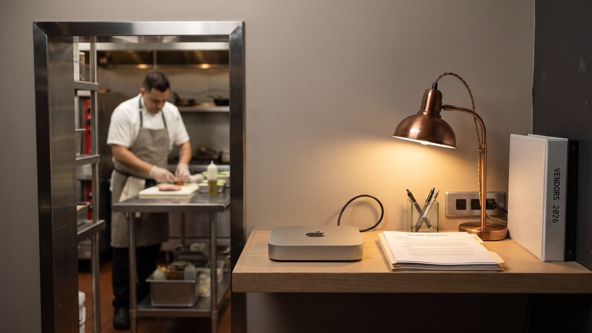 A Mac mini on a back-office shelf in a small restaurant beside a vendor binder, best automations for small business, Aceleron Intelligence