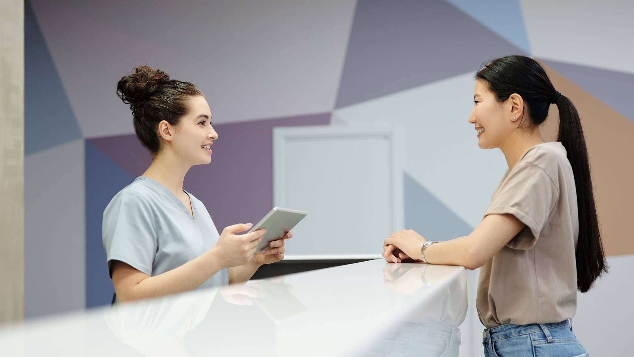A front desk team member with a tablet checking a client in at a bright modern storefront office, ai assistants recommending local businesses, Aceleron Intelligence